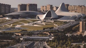 A modern architectural complex with unique curved structures, surrounded by high-rise residential buildings and a busy highway. - Will Hotel (Baku)