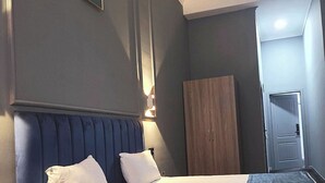 A hotel room with a bed, a wardrobe, and a door. - Will Hotel (Baku)