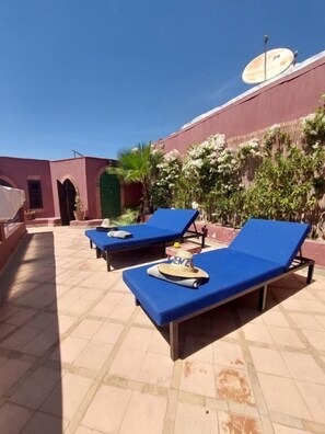 A rooftop pool area with blue lounge chairs and a satellite dish. - RIAD KENZO (Marrakech)
