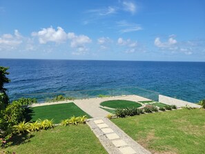 A landscaped garden with a pathway leading to a seating area overlooking the ocean. - Stara's Escape a Coastal Haven - Entire home in Scarborough, Tobago (Scarborough)