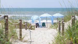 A beach pathway leading to beach umbrellas and beach chairs. - Bluebird By the Sea: Almost Oceanfront with Private Hot Tub! (Emerald Isle)