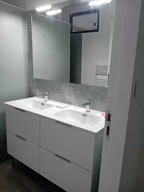 Chuveiro, secador de cabelo, toalhas de banho, papel higiênico