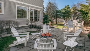 A patio with Adirondack chairs and a fire pit. - Kennebunk Coastal Getaway ! 2 minutes from Gooch's Beach ! (Kennebunk)