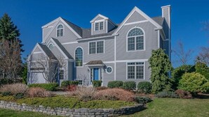 A large, two-story house with a stone foundation, multiple windows, and a well-maintained lawn. - Kennebunk Coastal Getaway ! 2 minutes from Gooch's Beach ! (Kennebunk)