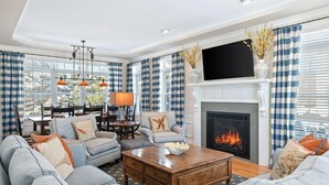 A living room with a fireplace, checkered curtains, and a television. - Kennebunk Coastal Getaway ! 2 minutes from Gooch's Beach ! (Kennebunk)
