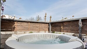An outdoor hot tub with a wooden fence and trees in the background. - The Ultimate Palermo Soho Oasis BBQ and Jacuzzi! (Buenos Aires)
