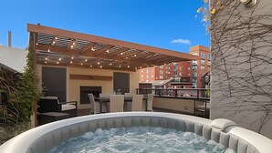 A rooftop terrace with a hot tub, outdoor seating, and a view of a red brick building. - The Ultimate Palermo Soho Oasis BBQ and Jacuzzi! (Buenos Aires)