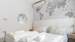 A hotel room with a large bed, a bedside table, a lamp, and a world map on the wall. - The Ultimate Palermo Soho Oasis BBQ and Jacuzzi! (Buenos Aires)