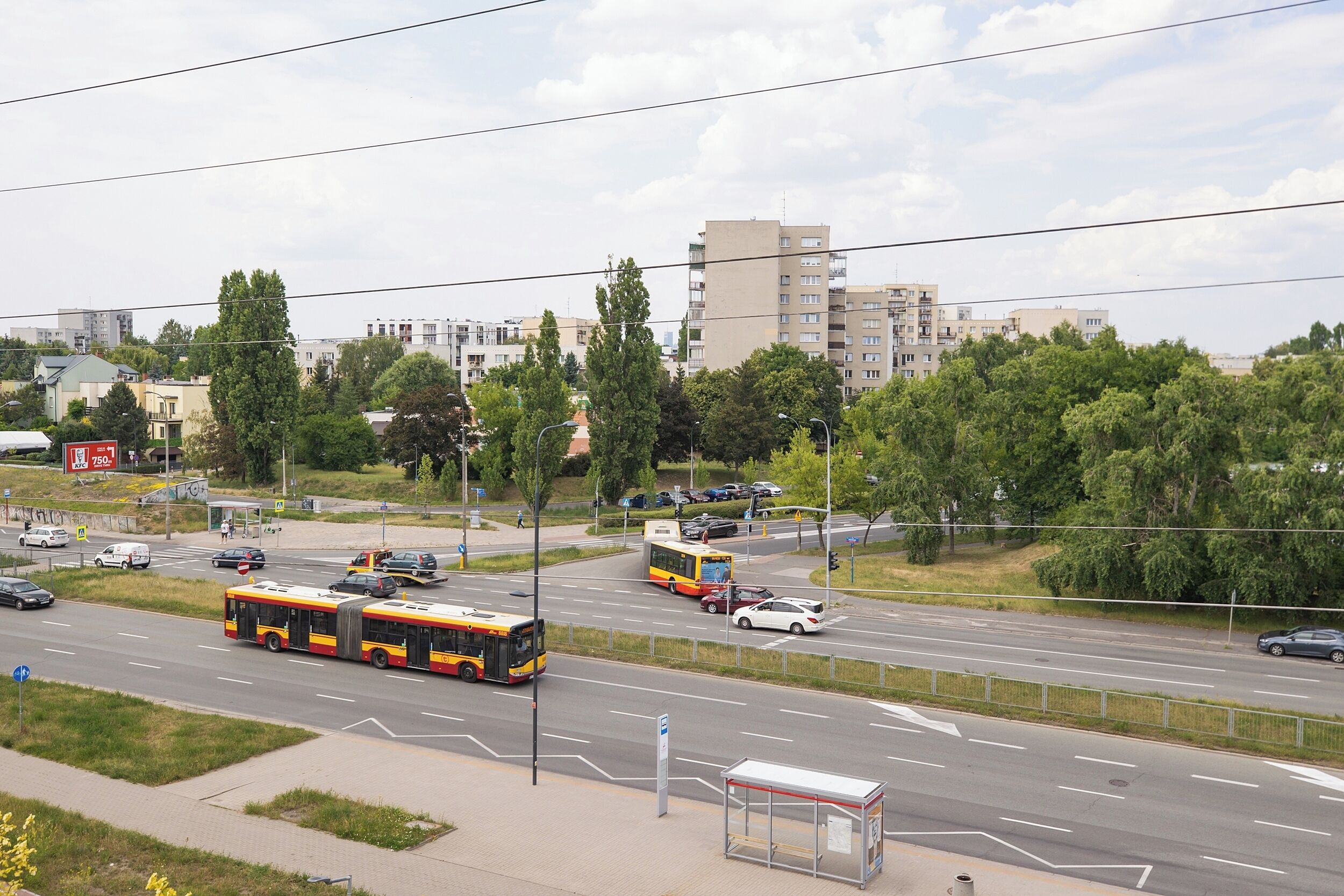 A multi-lane road with vehicles, a bus, and a pedestrian crossing.