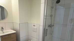 Ein Badezimmer mit Toilette, Waschbecken und Dusche.