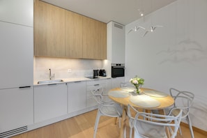 Departamento Deluxe, vista a la ciudad | Cocina privada | Refrigerador, microondas, horno y parrilla de estufa 