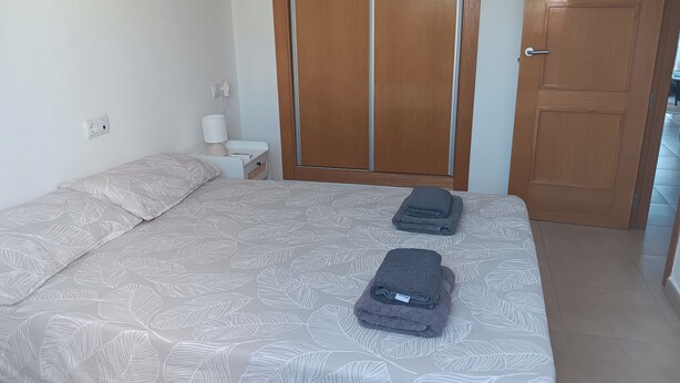 Une chambre à coucher avec un lit, une table de chevet, une armoire et une porte.