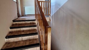 A staircase with wooden railings and a radiator on the wall. - Apartmány ŠTĚSTÍ (Bechlin)