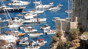 A marina filled with various boats and yachts, with people enjoying the water.