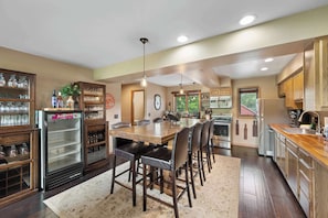 A spacious kitchen with a central island, wooden cabinets, and a built-in refrigerator.