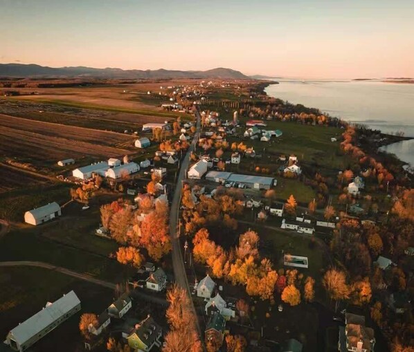 Vista aérea de un pequeño pueblo con casas, una calle principal y campos.