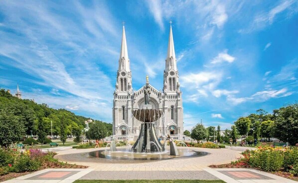 Eine prächtige Kathedrale mit zwei Türmen, einem zentralen Brunnen und einem umlaufenden, angelegten Garten.