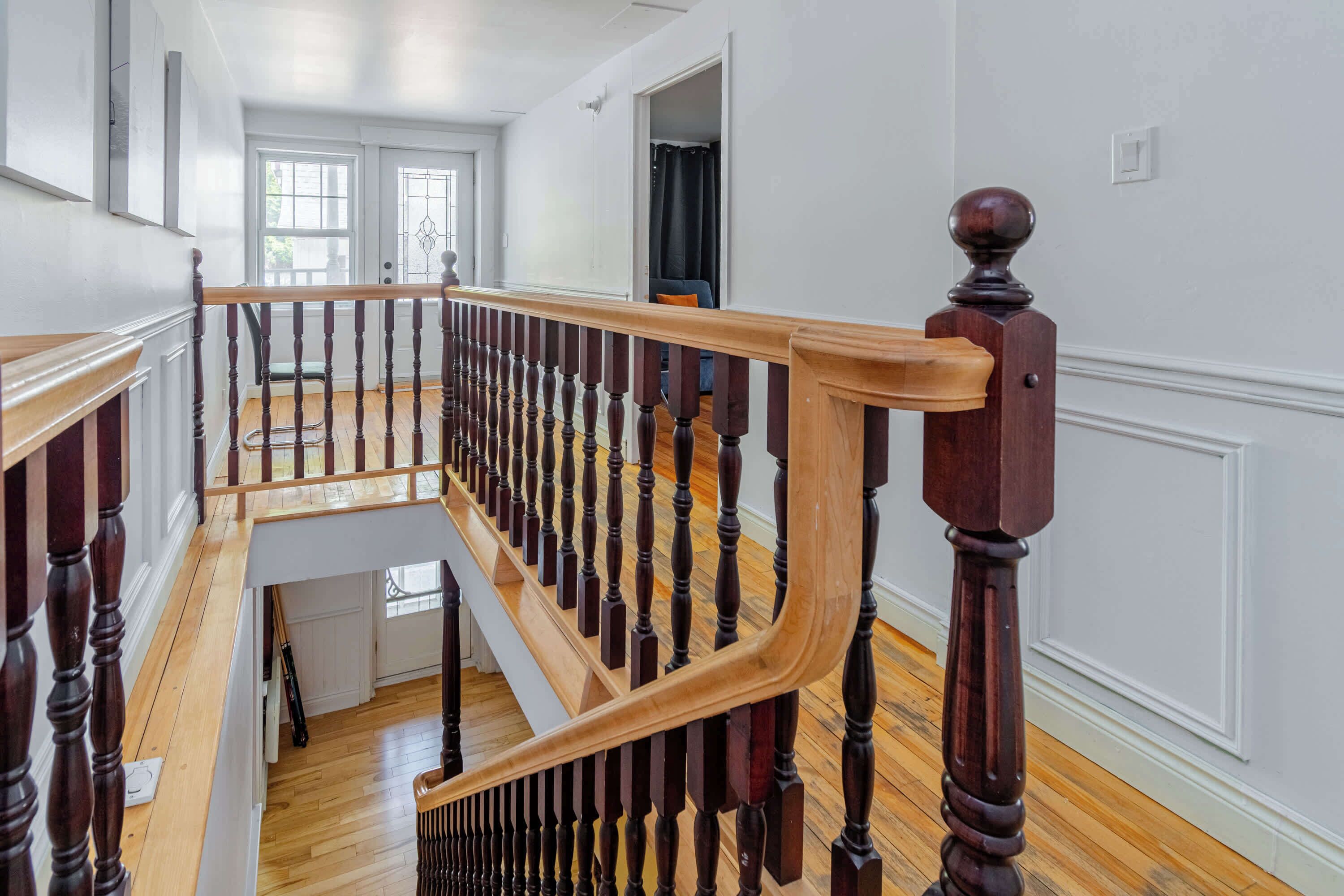 A wooden staircase with a balustrade leading to a second-floor landing.
