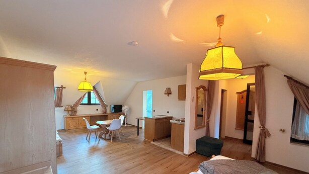 Ein geräumiges Zimmer mit einem großen Bett, einem Schreibtisch und einem Essbereich.