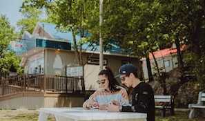 Two people sitting at an outdoor table with a view of a building in the background.