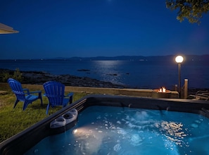 Ein Whirlpool mit Blick auf das Meer in der Nacht.