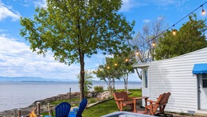 A hot tub, outdoor chairs, a small table, a fire pit, and a view of the lake.