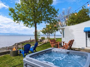 Un jacuzzi, sillas exteriores, una mesita, un brasero y vistas al lago.