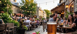 An outdoor dining area with tables and chairs, a glass of beer, and string lights.