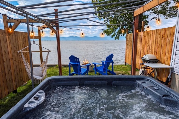 Détendez-vous dans le spa en profitant d’une vue imprenable sur le fleuve. Les chaises Adirondack colorées ajoutent une touche conviviale et chaleureuse pour savourer pleinement vos instants de détente en nature.