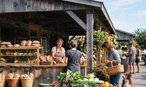 A rustic outdoor market stall with bread and vegetables.