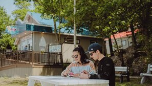 Two people sitting at an outdoor table with a view of a building in the background.