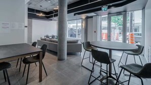 A modern office space with a large table, several chairs, a sofa, and a large pillar. - The 708 | For 4 People | Free Parking | BBQ (Québec)