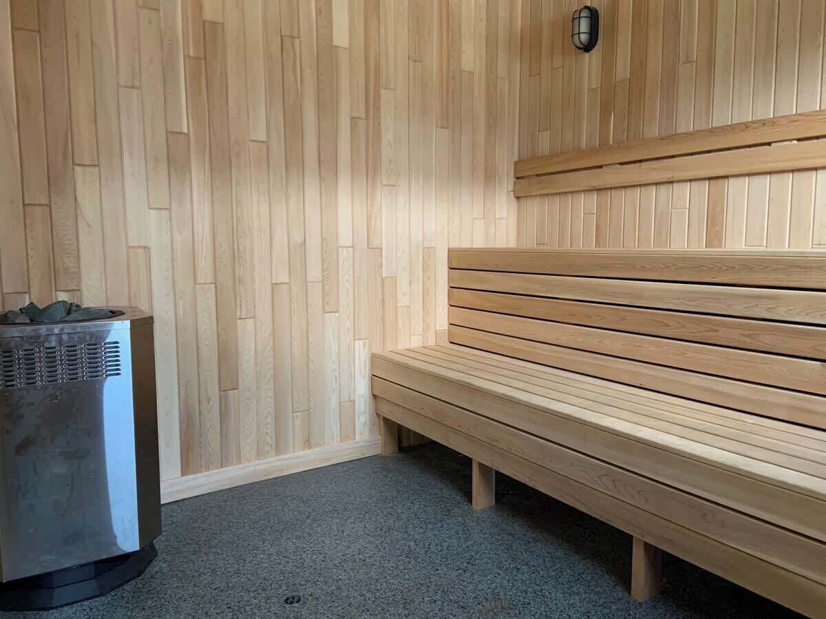 Ein Saunaraum mit einer Holzbank und einer Saunaheizung.