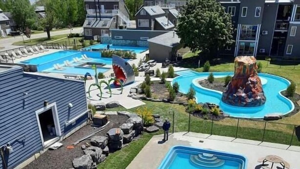 Ein Wasserpark mit mehreren Rutschen und Pools, umgeben von Wohngebäuden.