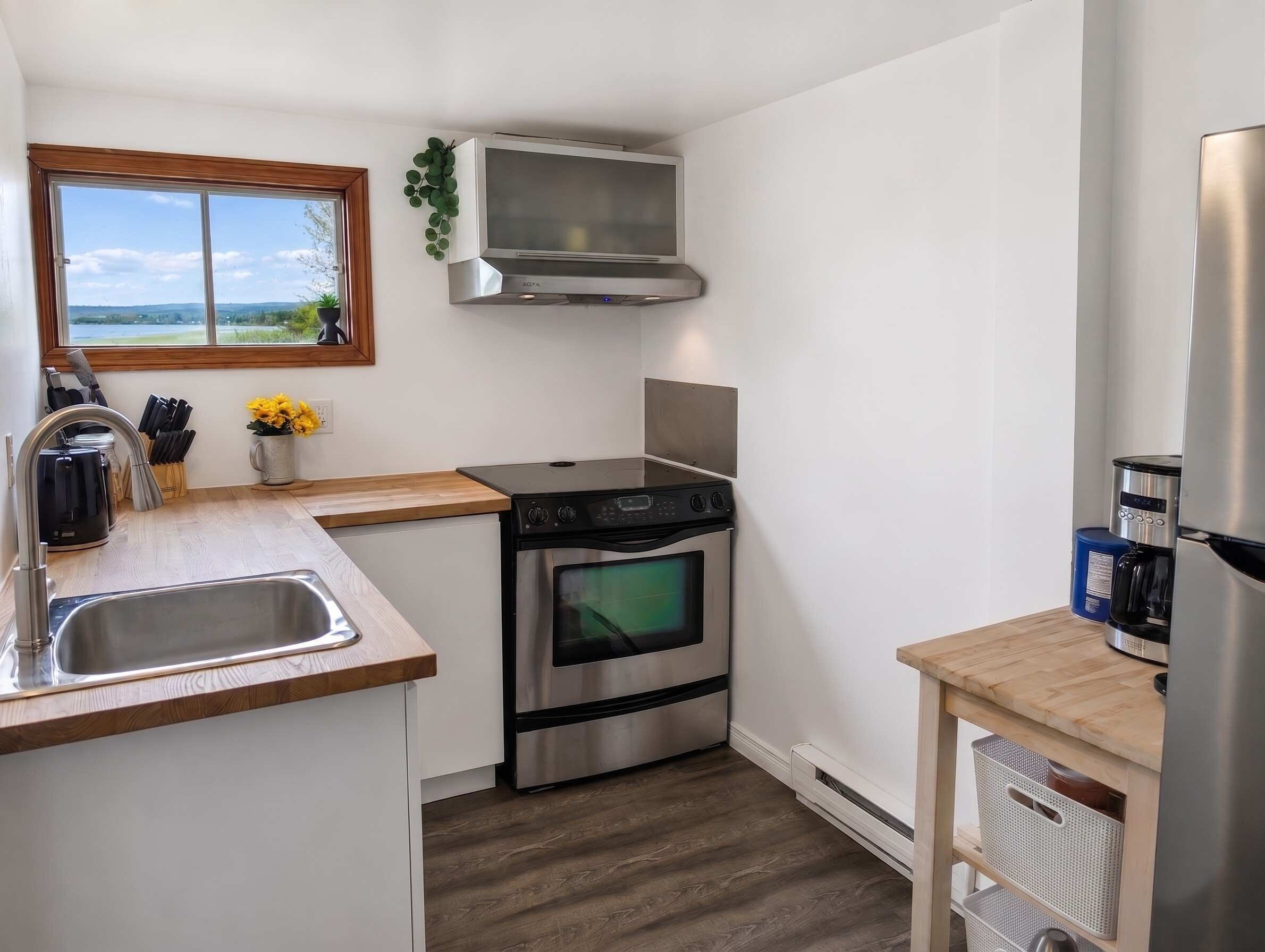 A compact kitchen with a built-in oven, a stovetop, a microwave, and a coffee maker.