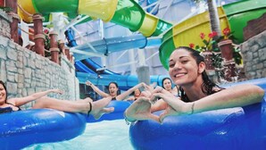 An indoor water park with inflatable tubes and a stone wall.