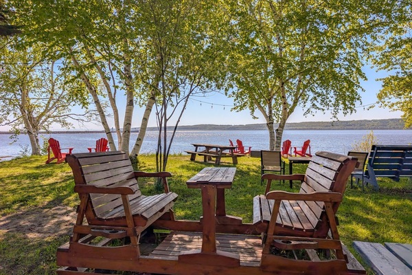 Confort au bord du lac : détendez-vous, dînez ou profitez simplement de la vue à l’ombre des arbres.