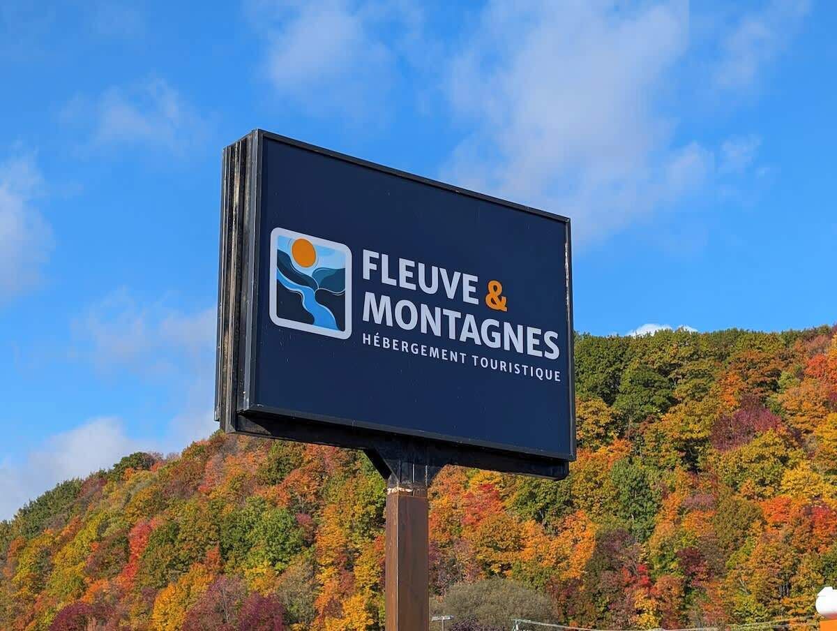 Une enseigne pour « Fleuve & Montagnes Hébération Touristique », avec un logo et du texte.
