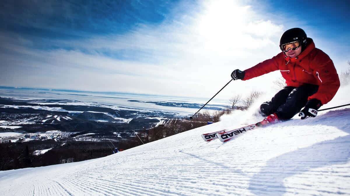 A skier in a red jacket on a snowy slope.