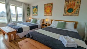 Una habitación con dos camas, bancos de madera y decoración en las paredes.