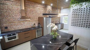 Een moderne keuken met een bakstenen muur, roestvrijstalen apparatuur en een marmeren aanrecht.