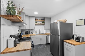 A modern kitchen with white cabinets, stainless steel appliances, and wooden countertops. - Relaxed 1BR Mountain Escape | Fireplace & Parking (Steamboat Springs)