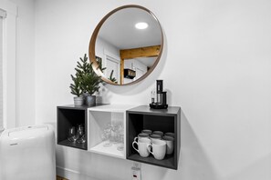 A modern kitchen with a white refrigerator, a coffee maker, and shelves with glasses and mugs. - Relaxed 1BR Mountain Escape | Fireplace & Parking (Steamboat Springs)