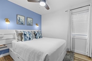 A bedroom with a bed, a ceiling fan, wall-mounted lights, and a window with blinds. - Relaxed 1BR Mountain Escape | Fireplace & Parking (Steamboat Springs)