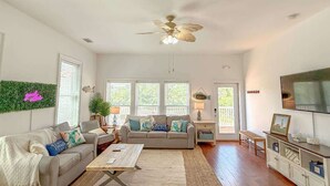 Ein Wohnzimmer mit einer Couch, Couchtisch, Fernseher und Deckenventilator.