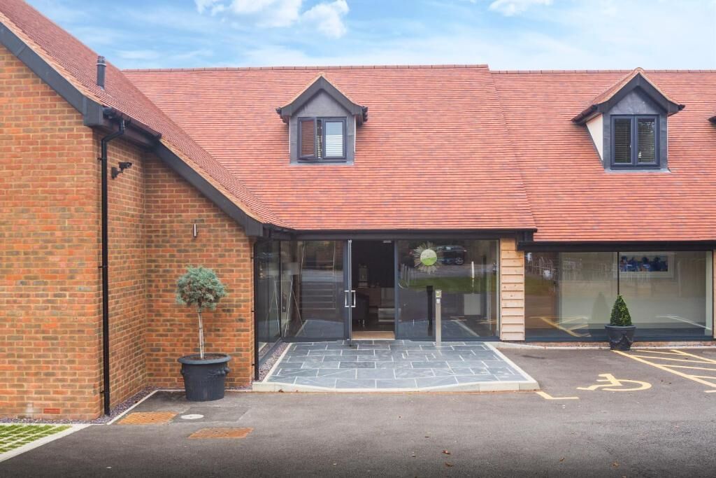 A building with a brick facade, a tiled roof, and a wheelchair-accessible entrance.