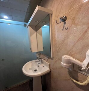 A bathroom with a pedestal sink, a mirror, and a hairdryer mounted on the wall. - Gabala City Hotel (Gabala)