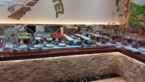 A buffet with various food items and a stone wall. - Gabala City Hotel (Gabala)