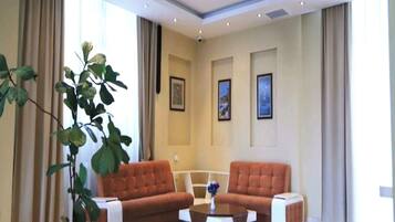 Ein geräumiges Wohnzimmer mit zwei Sofas, einem Couchtisch und einer großen Topfpflanze.