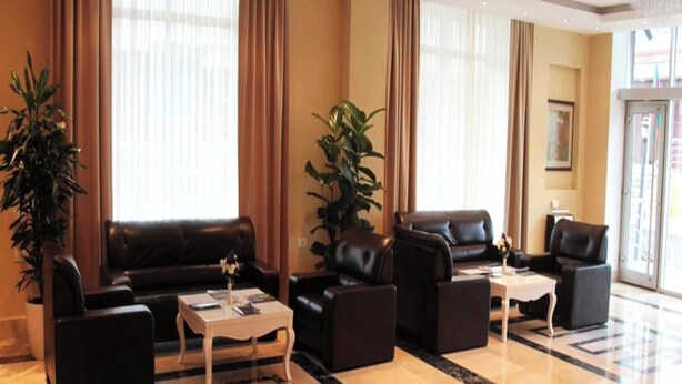 A modern hotel lobby with leather sofas, a coffee table, and potted plants. - Gabala City Hotel (Gabala)